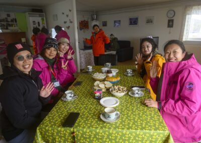 Guests sitting at table having coffee & cake in Greenlandic home