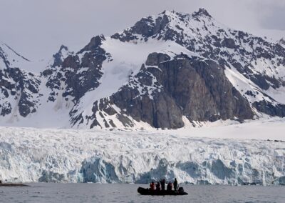 Zodiac cruising in front of glacier in Svalbard
